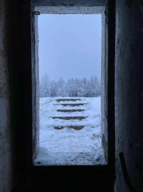 a snowy landscape seen through an open window