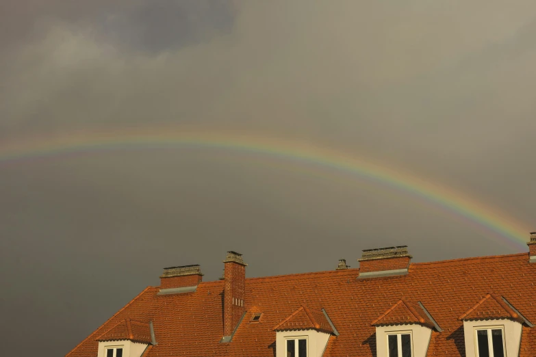 a rainbow is visible over some red clay houses