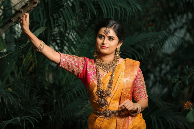 a woman standing near leaves wearing a traditional costume