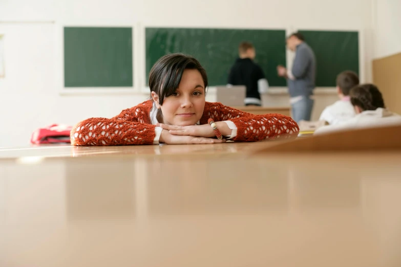 a woman sits at the table with her arms folded out