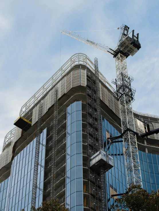 a large crane on top of some glass buildings