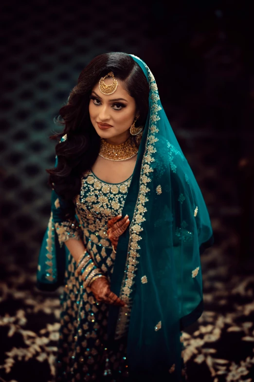 a woman in green and gold bridals posing