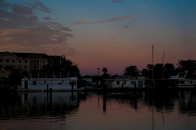 the setting sun reflects in the still water and is reflecting the houses