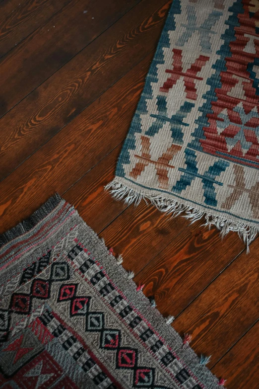 some wood floors with rugs laying on top of it