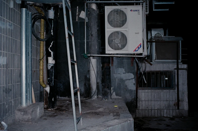 an air conditioner and ladder outside a small building