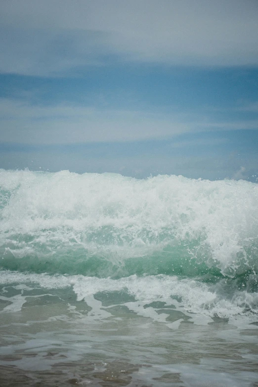 a man surfing in the ocean on an overcast day