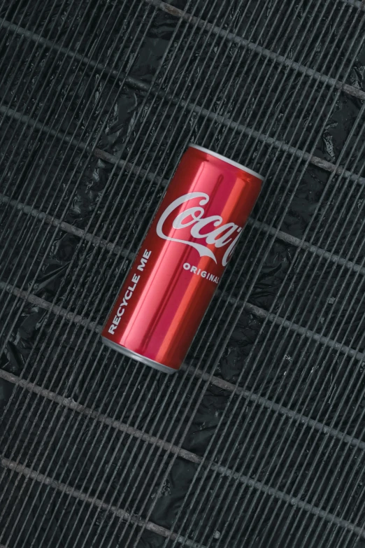 a red and black coke can sitting on top of a grill