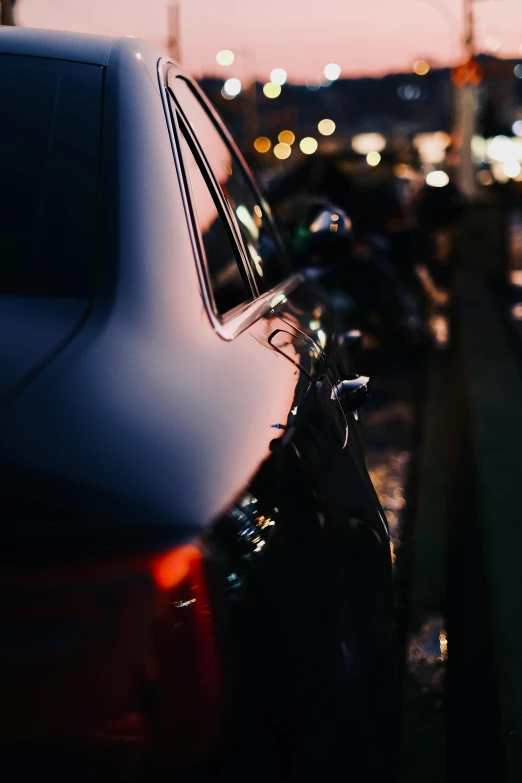 several cars parked at a side walk in the evening