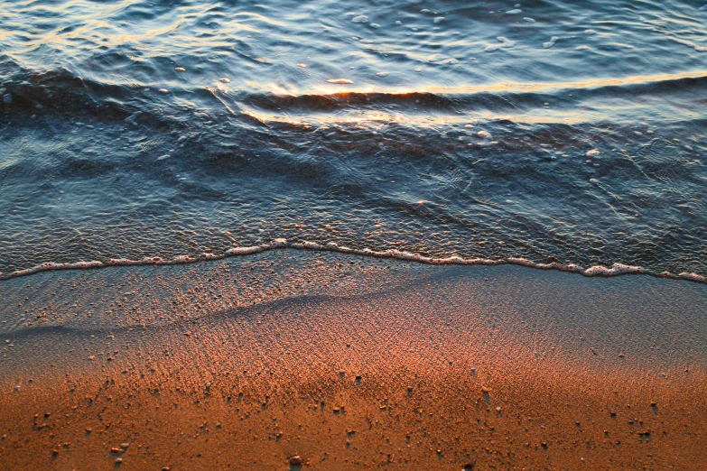 a view of an ocean shore with sand and water