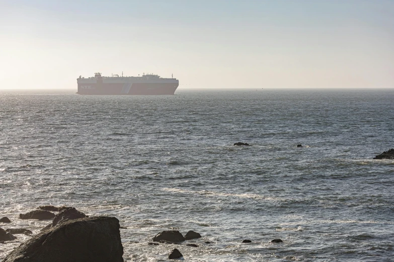 a large boat on the ocean near the rocks