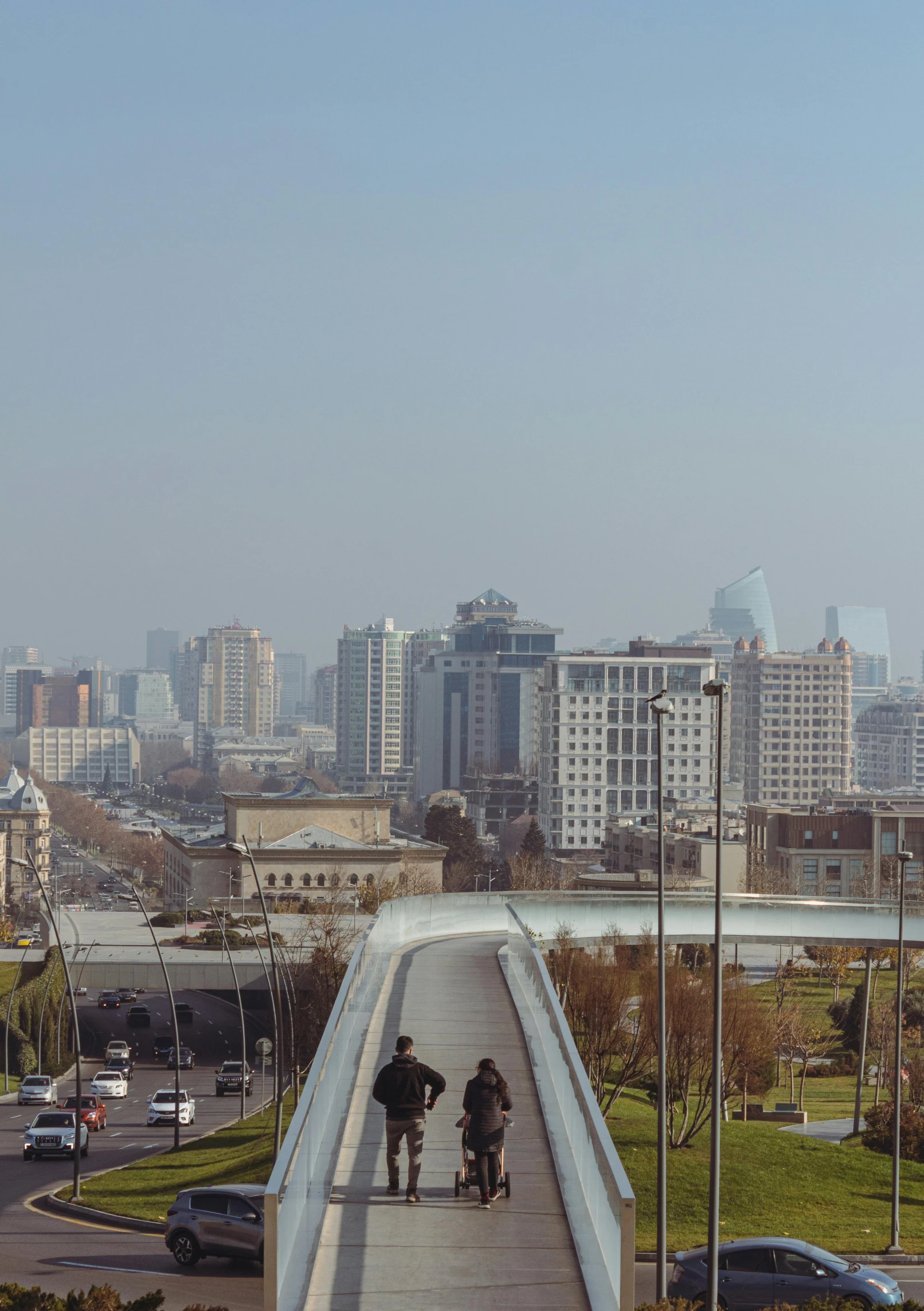 the people are walking in the city on a walkway