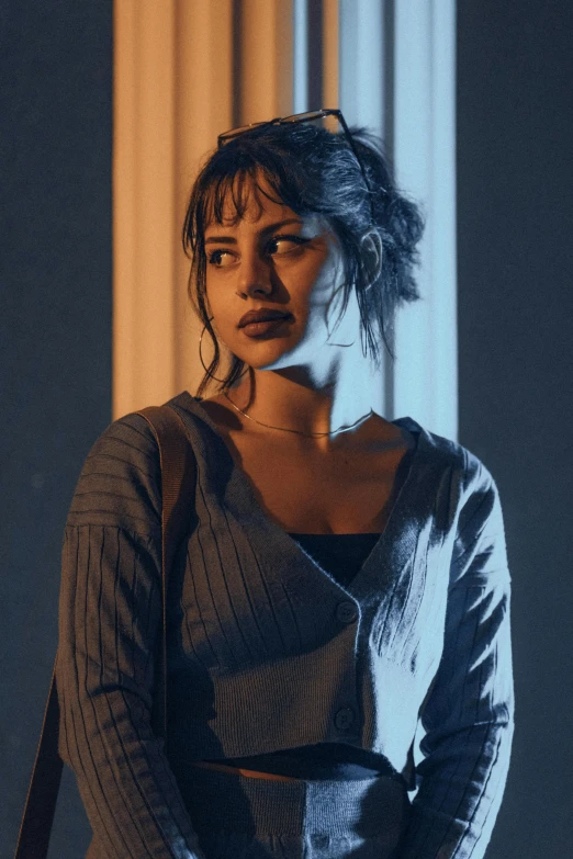 a woman with blue hair is standing in front of a wall