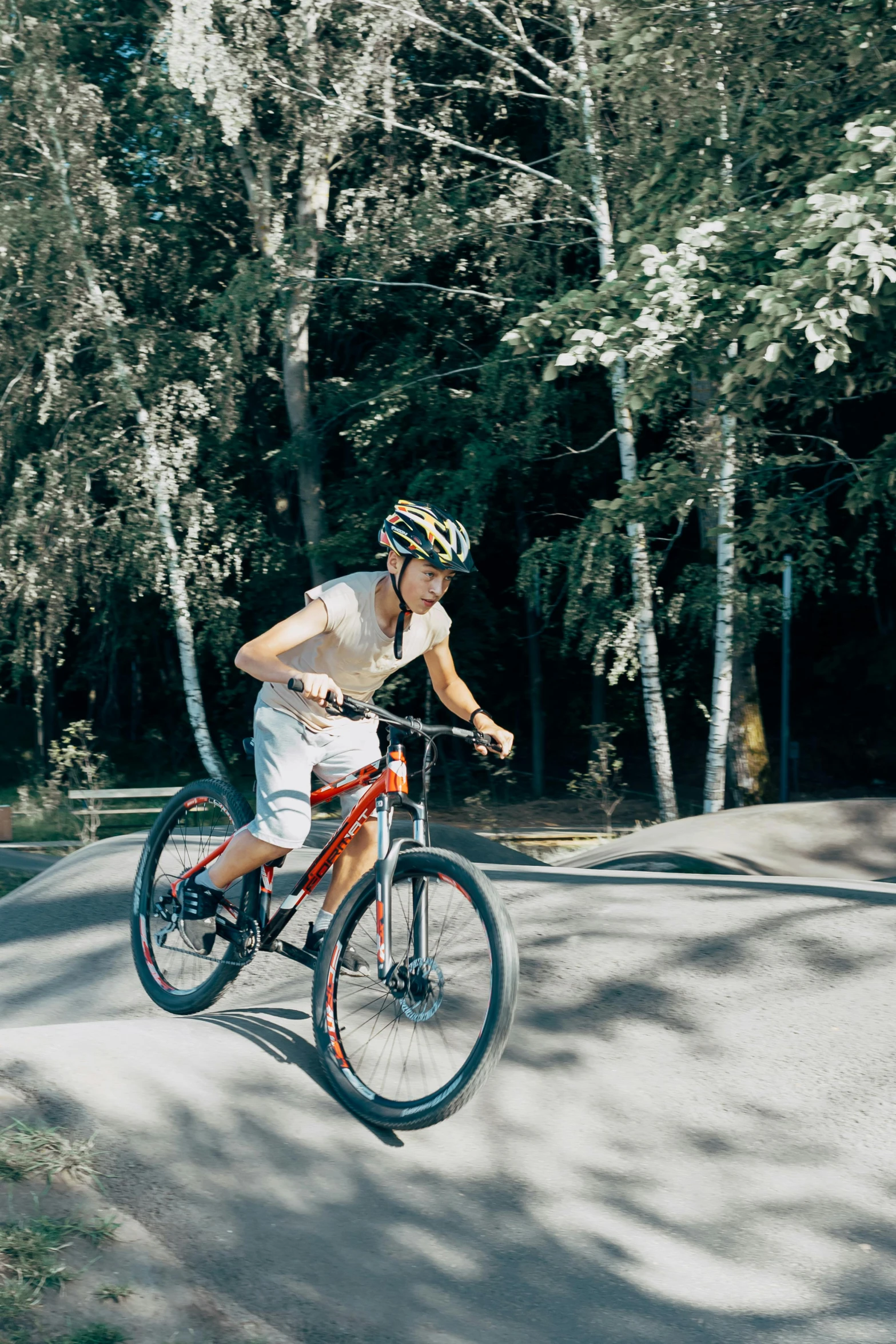 a boy riding his bike and jumping over the other