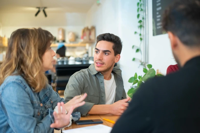 a group of people talking around a table