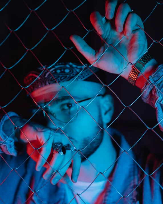 a man standing in front of a chain link fence