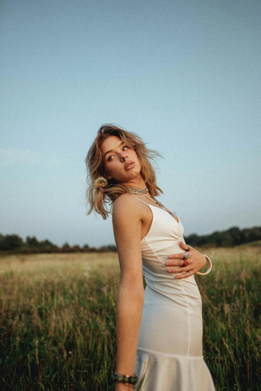 woman wearing a white dress standing in a field