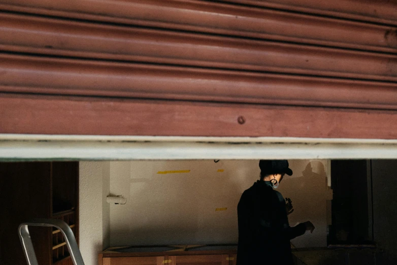 a man in black coat and a red hat and a suitcase