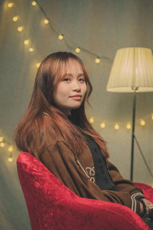 a girl is sitting in a red chair