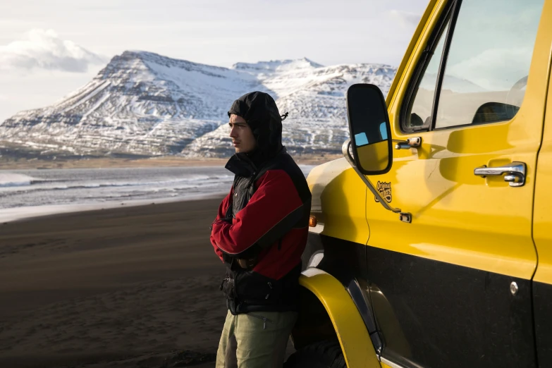 a young man leaning against the side of a truck