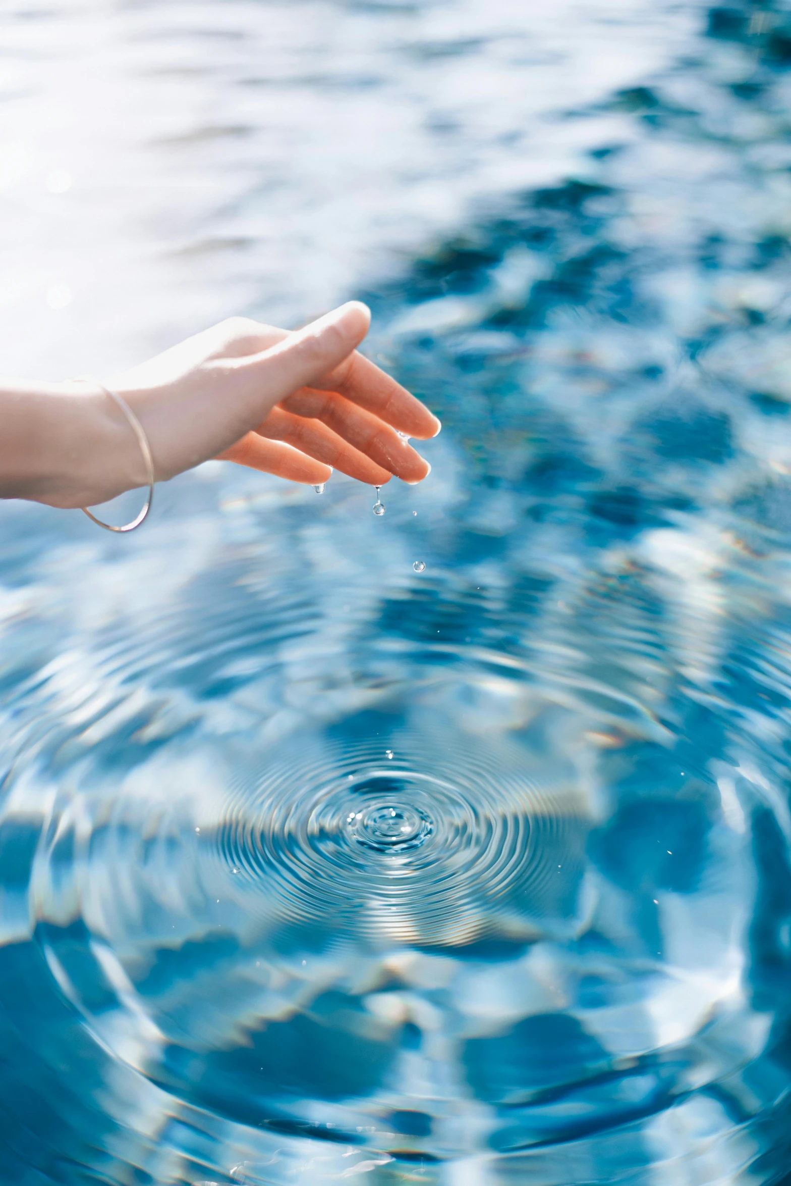 a woman's hand reaching out for soing in the water