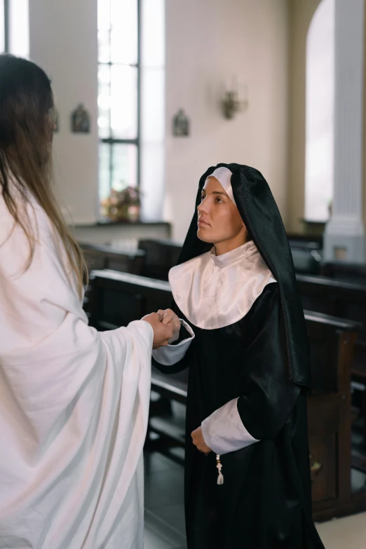 a nun is giving a priest an orange carrot