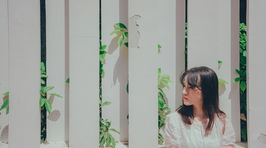 the woman is standing next to the fence outside