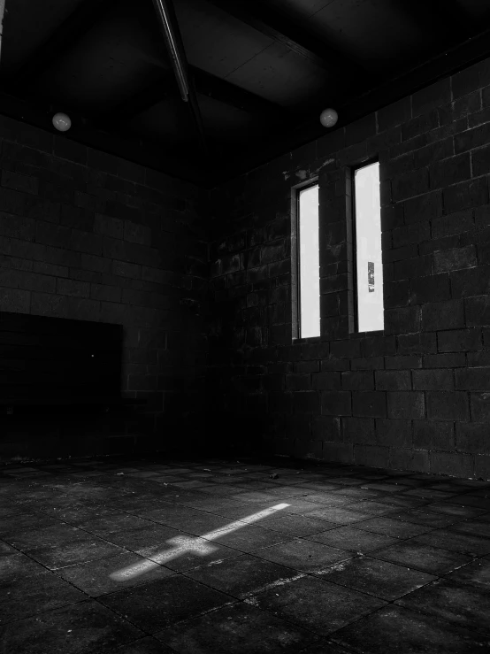 black and white pograph of an empty room with three open windows