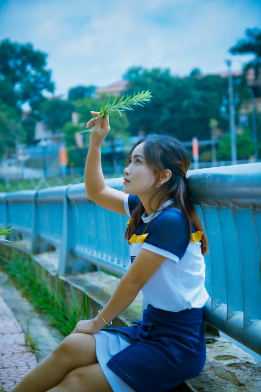 a girl with a flower in her hand on the rail