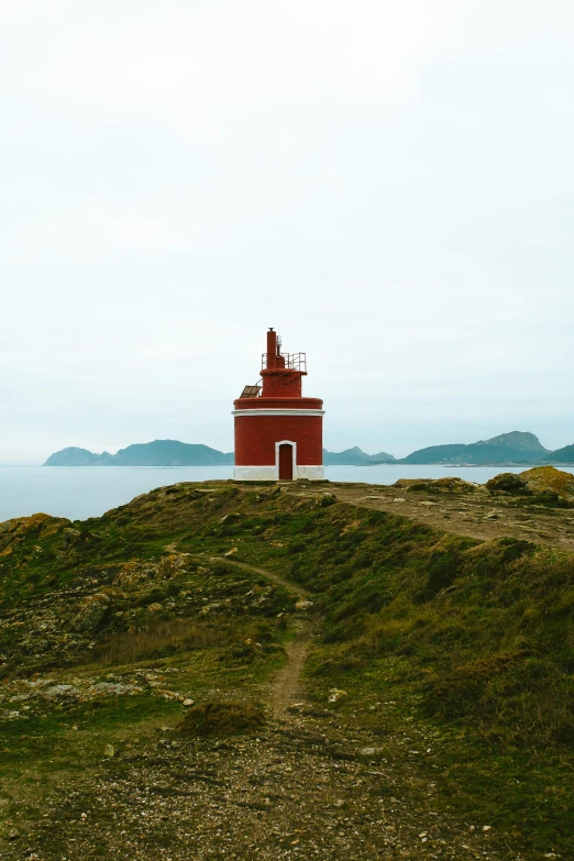 a lighthouse on top of a cliff with green grass