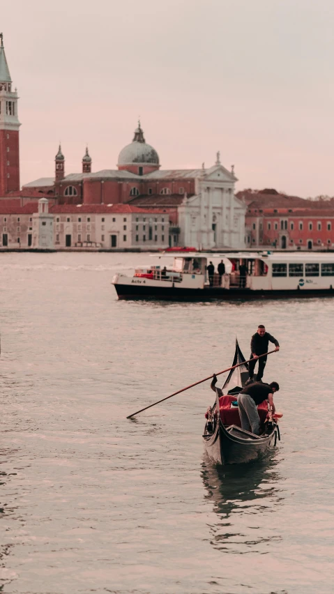 a small boat floats in front of buildings along the water