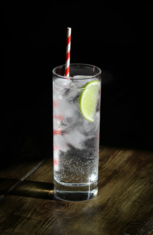 a glass full of ice and lime with two straws