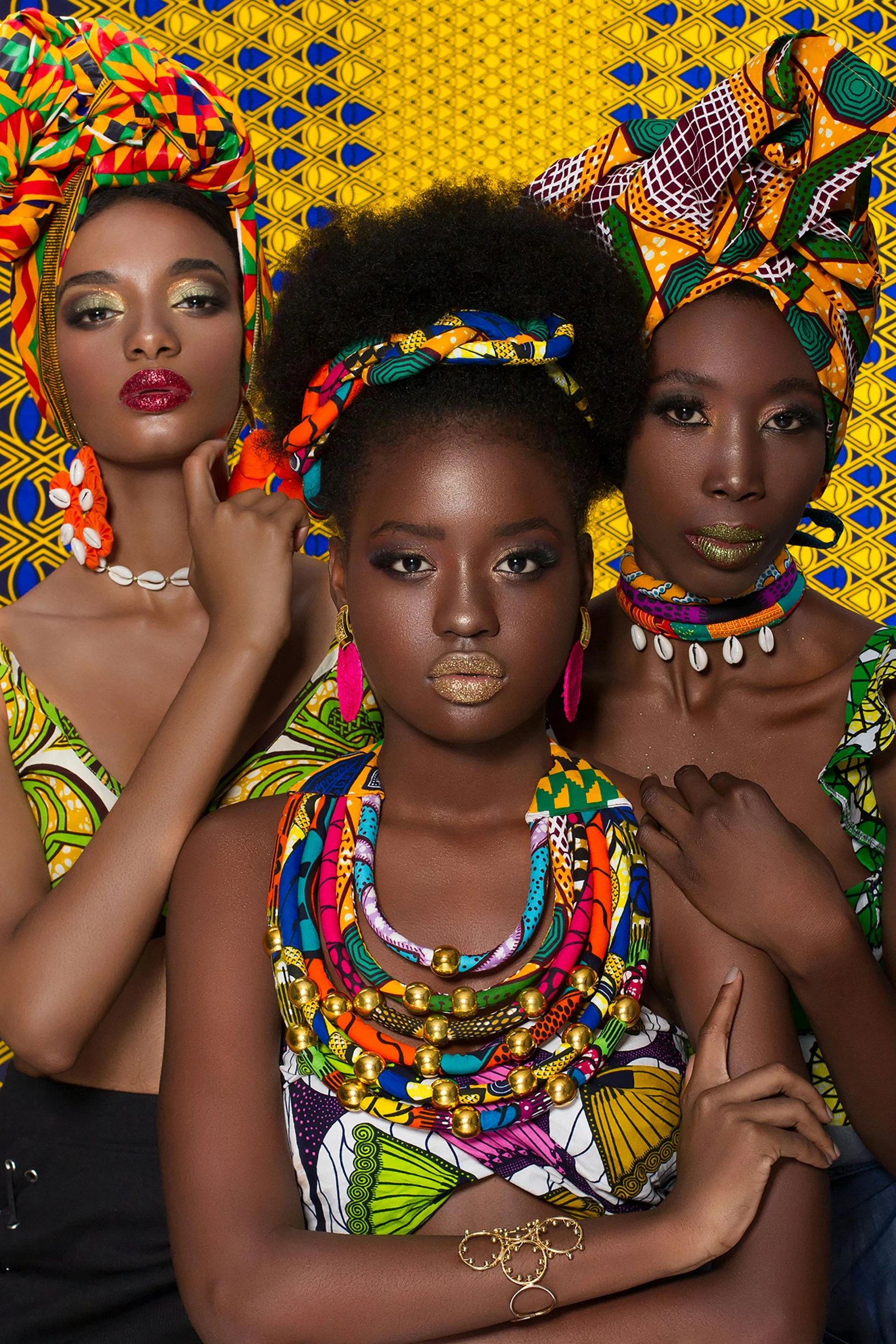 three black women with different colored necklaces and hair accessories