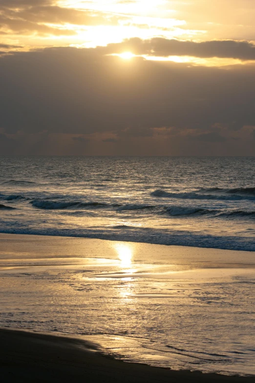 the sun shining brightly behind the clouds over water