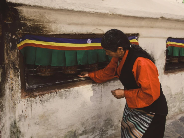 a woman looks through a window while holding an item