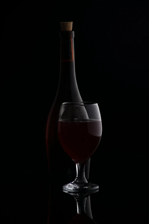 a glass and a bottle sitting on the table