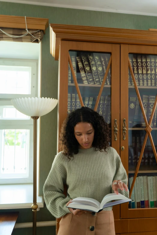 a woman reading a book in a green room