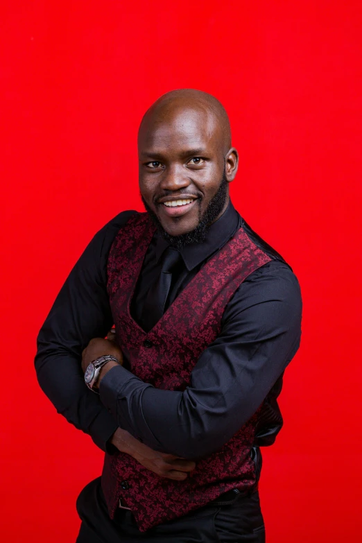 a man in a vest and tie smiles at the camera