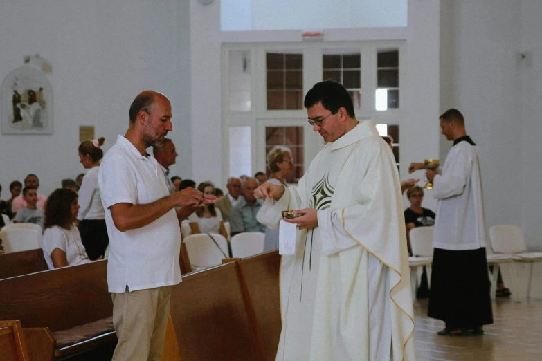 two men wearing white and standing in front of benches