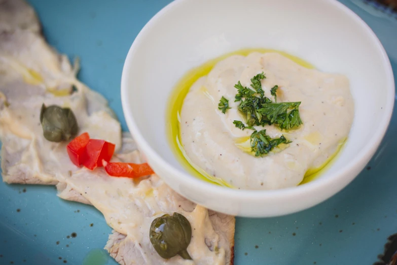 a plate with a soup with olives, pickles, and some ers