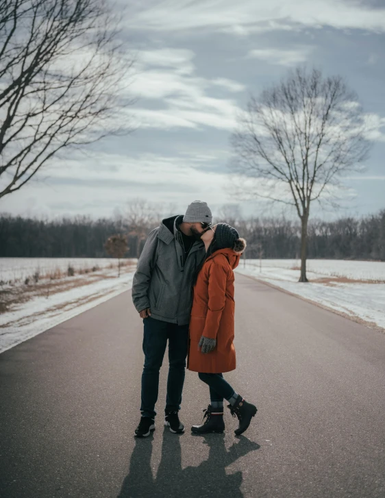 a man and woman standing next to each other on a street