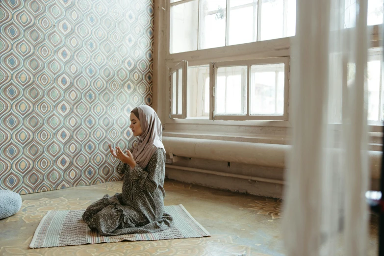 a woman is sitting on the floor praying