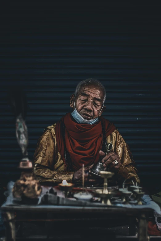 an old man holding a camera sitting down
