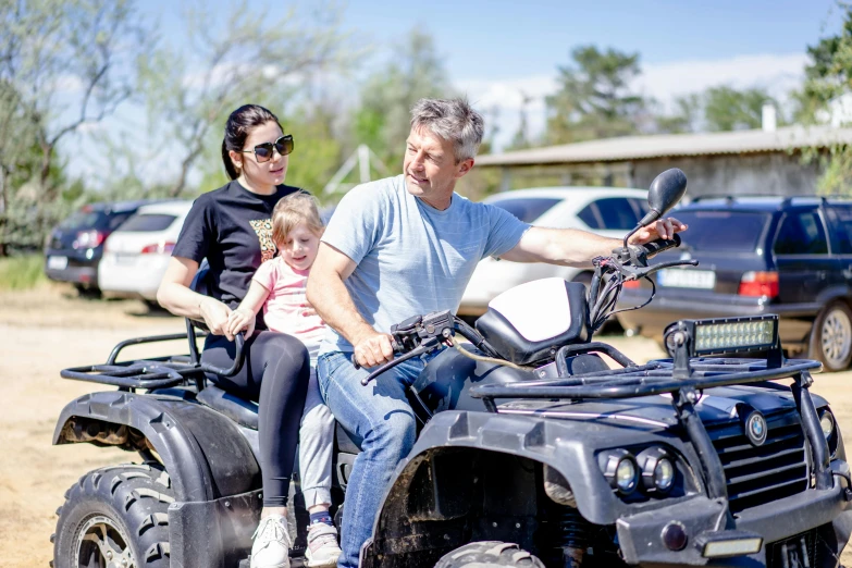 a man and girl riding on a large four wheeler