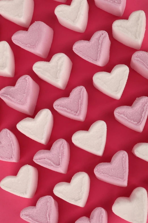 heart shaped marshmallows laid out on a pink surface