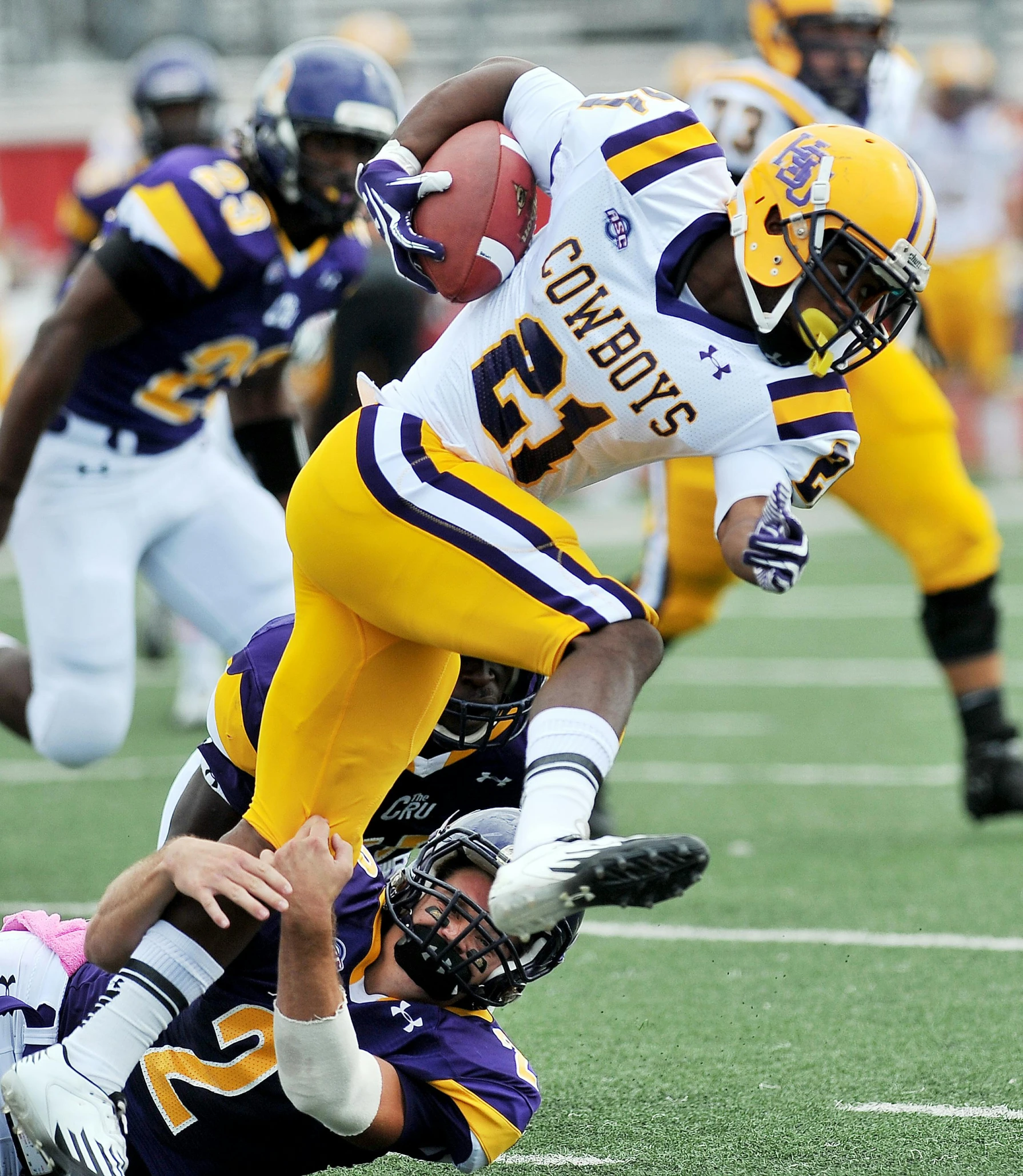 the football players are trying to make contact with the football