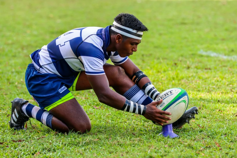 a young man squatted down with his hand on the ball