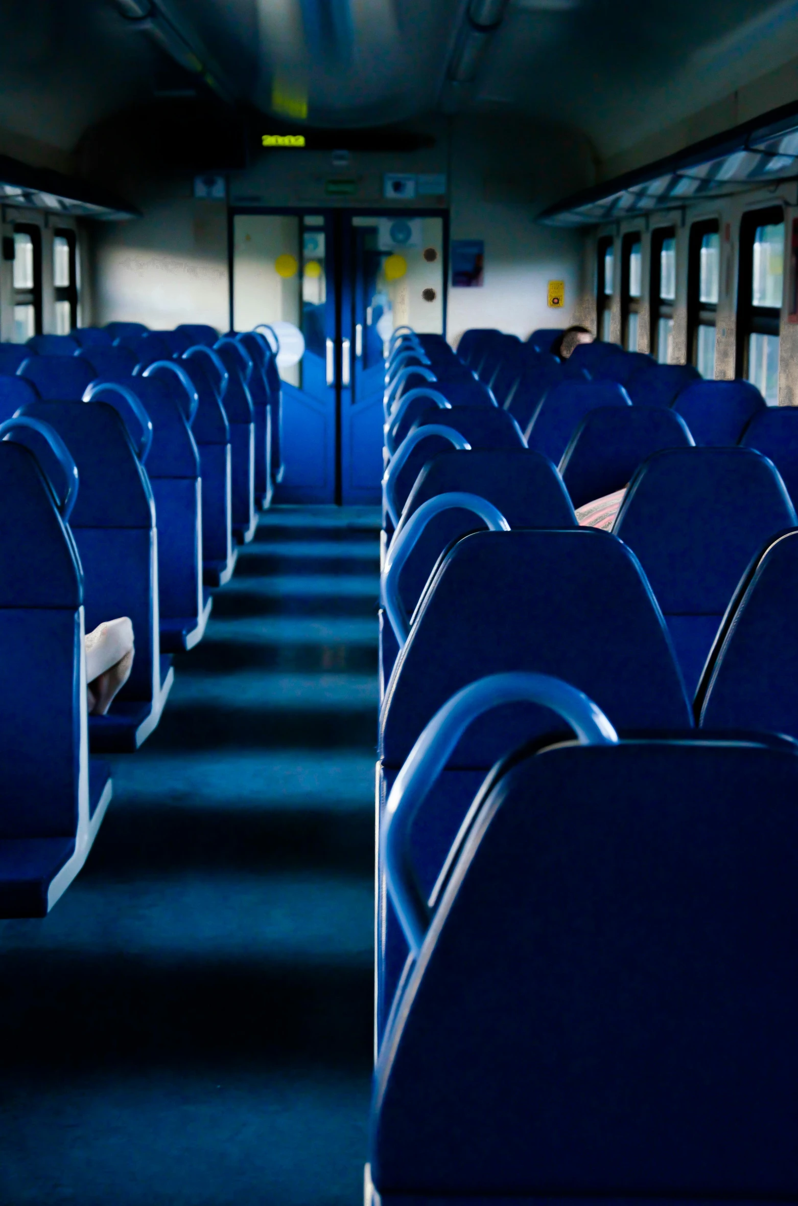 a long empty bus has blue seats