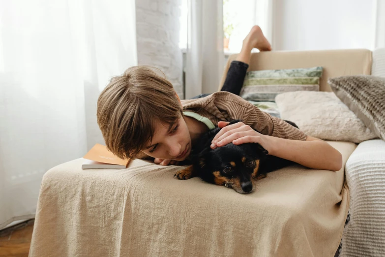 a woman lies on her side with her puppy