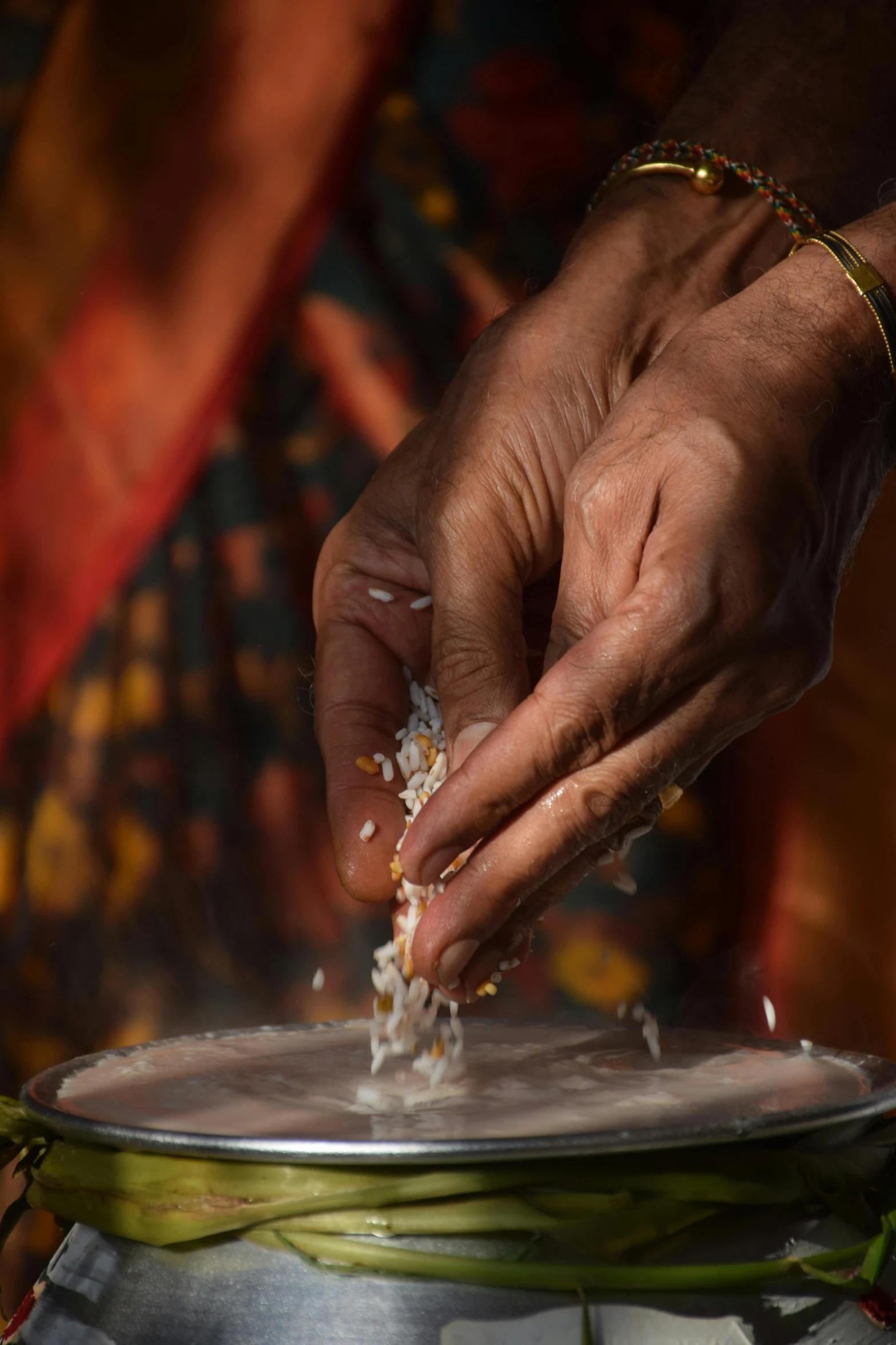 a woman is scooping food from her silver plate