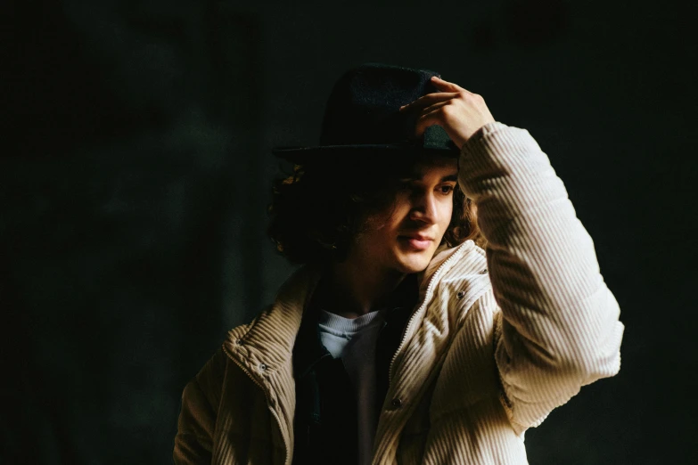 woman in black hat and sweater with hand on head